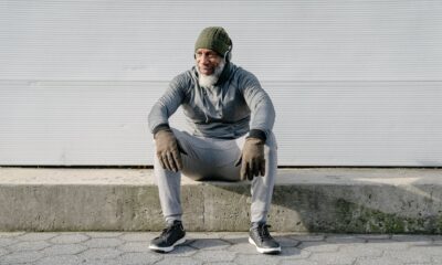 stylish black man with headphones resting on pavement